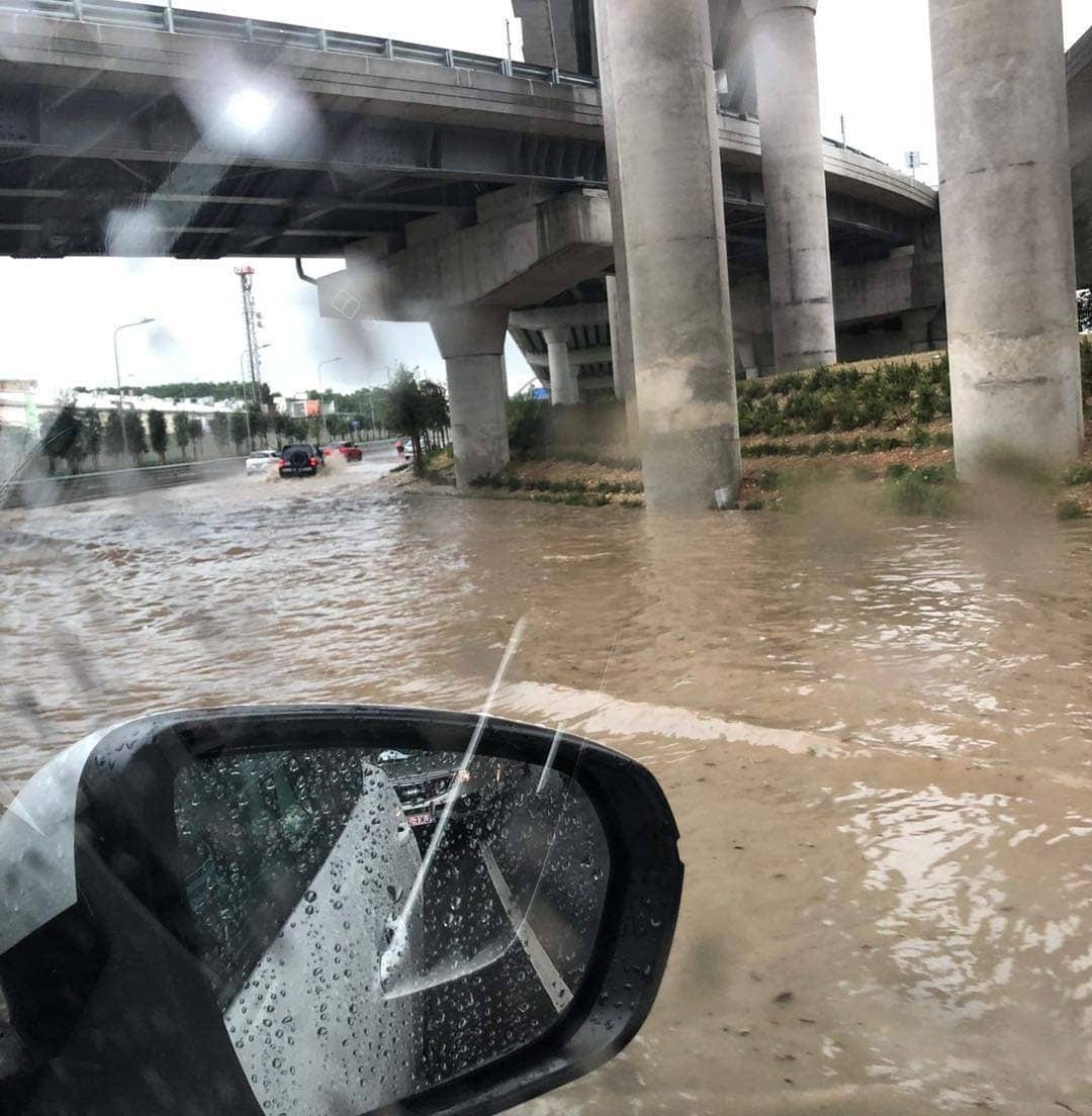 A flooded road reflected in a car's wing mirror