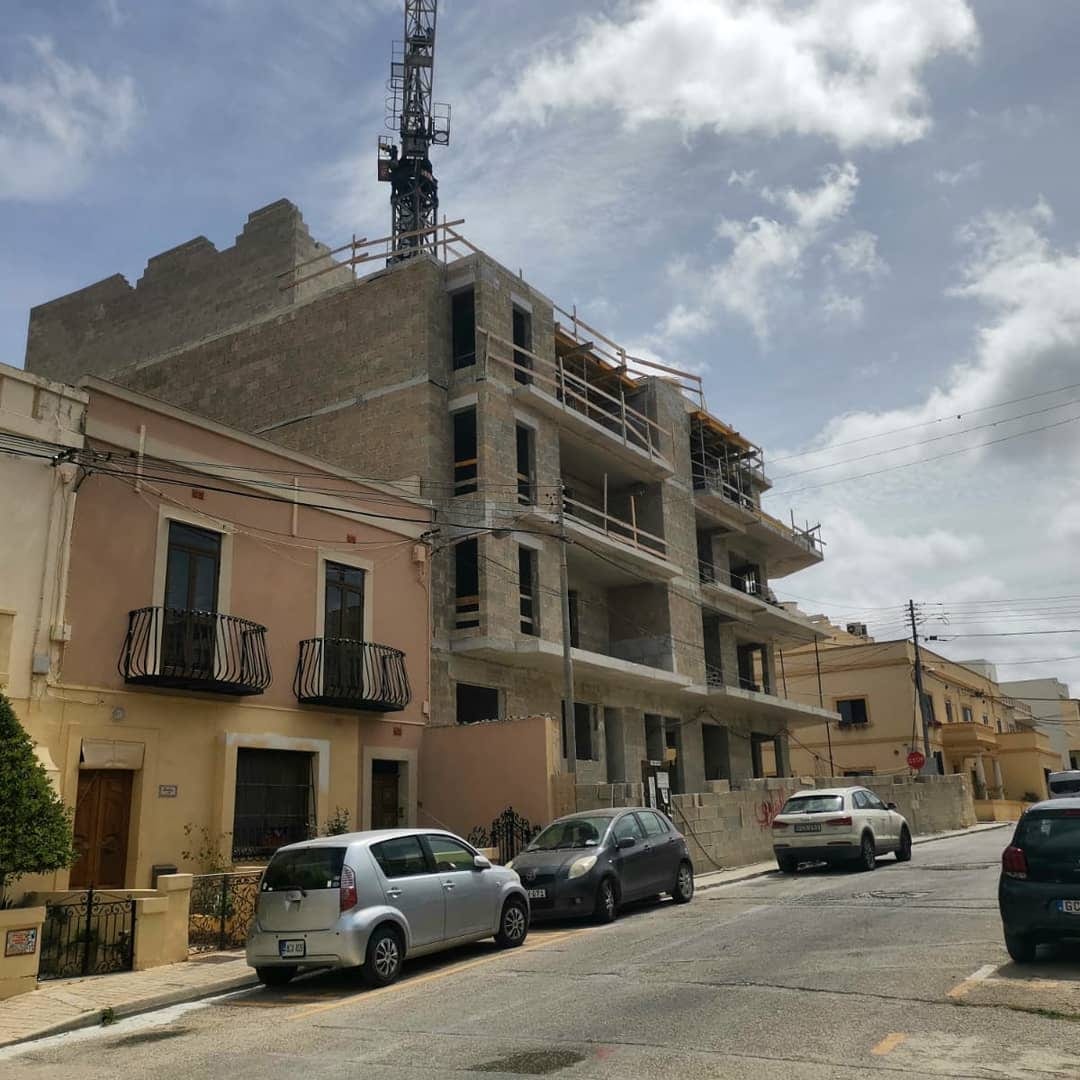 A street of stone buildings with a distant crane