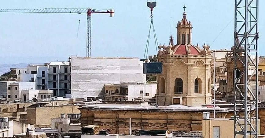 A church dome dwarfed by adjacent construction