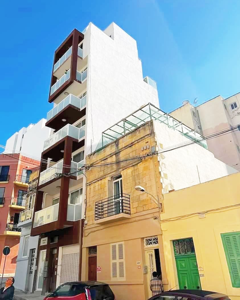 A building mid-construction with red edge railings