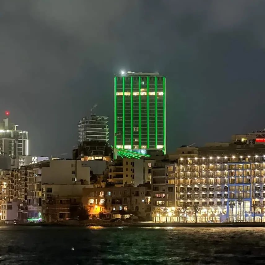 A lit tower at night amid construction
