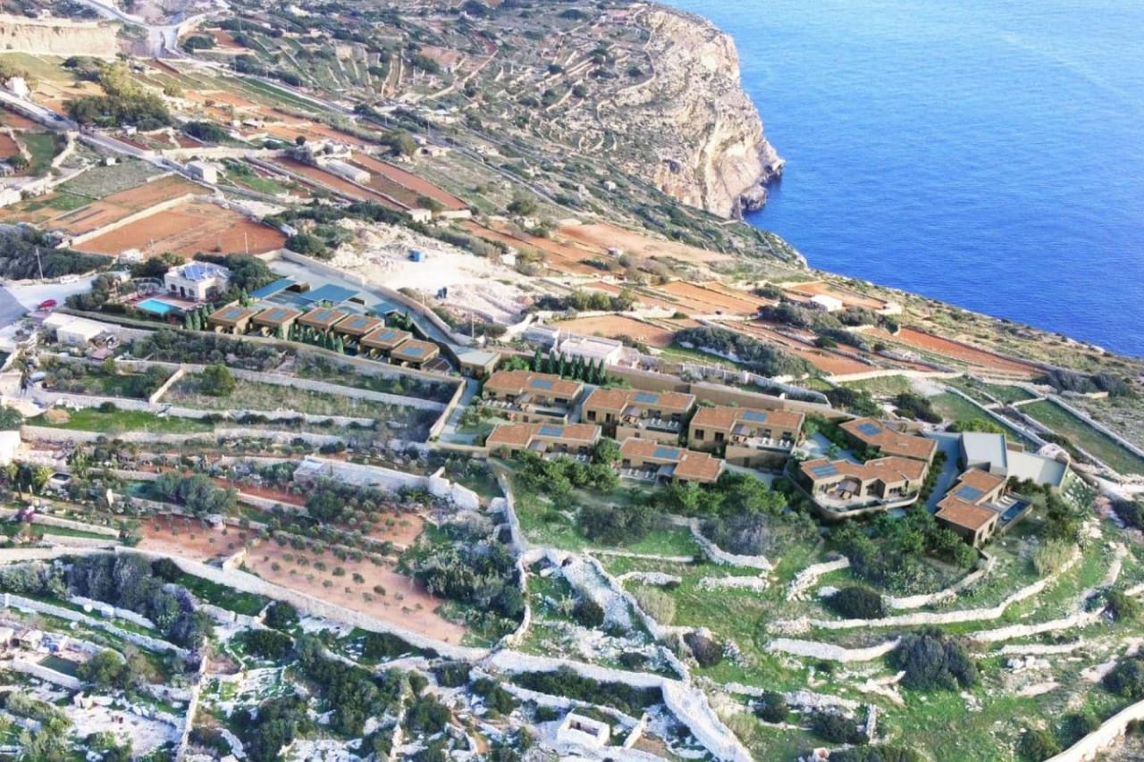 An aerial render of a bungalow complex spread across the Żurrieq clifftop above the sea